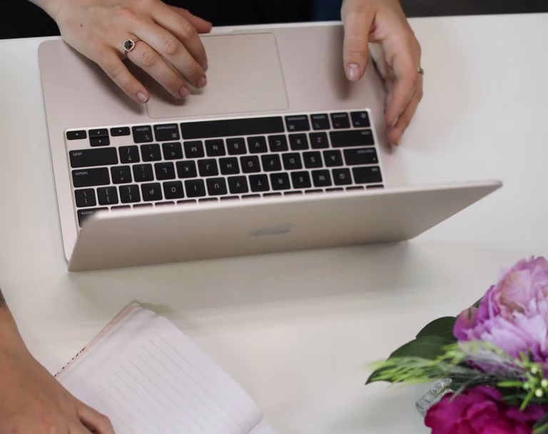 A person working on a laptop and taking notes while planning Google Ads strategies for Black Friday campaigns.
