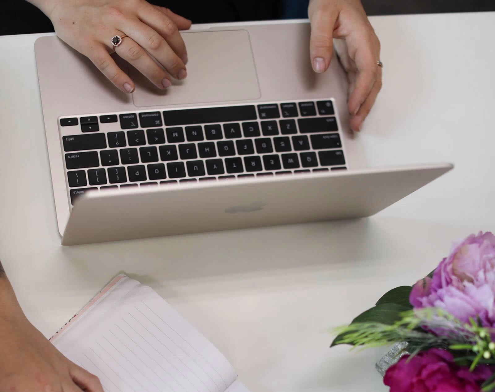 A person working on a laptop and taking notes while planning Google Ads strategies for Black Friday campaigns.