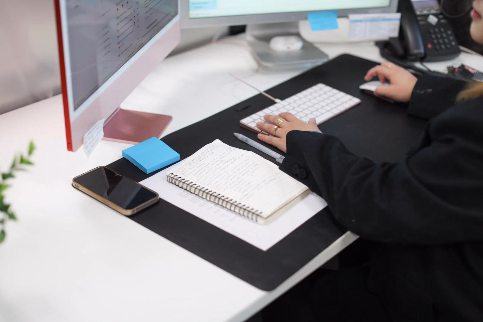 A marketing professional working on a computer and reviewing notes, focusing on optimizing bidding and budgets for the peak season.