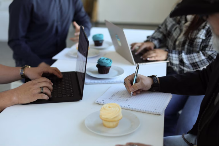 Two colleagues reviewing data on a laptop and phone, collaborating to Review Digital Marketing Performance to Plan for 2026 Success.