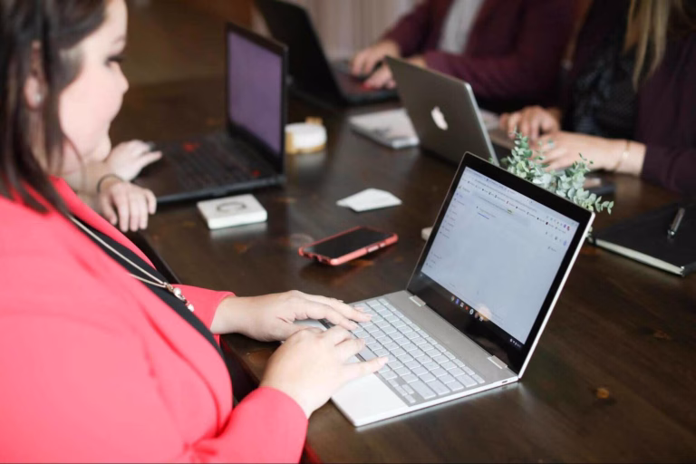 Hands of a professional marketer typing on a laptop with an SEO management dashboard visible, demonstrating the technical execution of SEO for small businesses.
