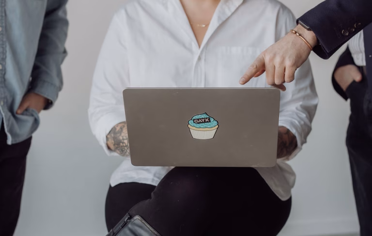 SEO vs PPC strategy discussion with a digital marketing team reviewing a laptop.